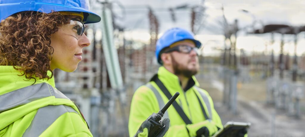 Engineers in high-visibility clothing working at an electricity substation